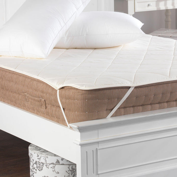 Factory seconds 100% cotton, wool filled mattress topper and protector secured to a bed with elasticated straps