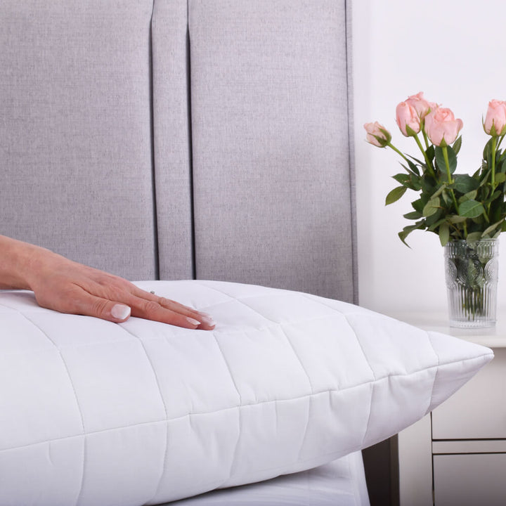 Hand pressing down on 100% cotton pillow protector