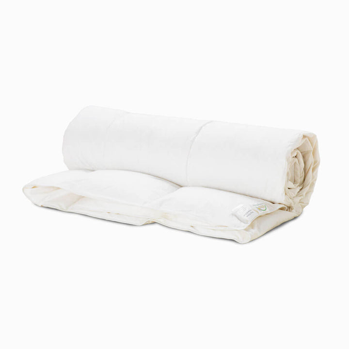 4.5 tog summer goose feather and goose down duvet, encased in 100% cotton, rolled up and isolated on a white background