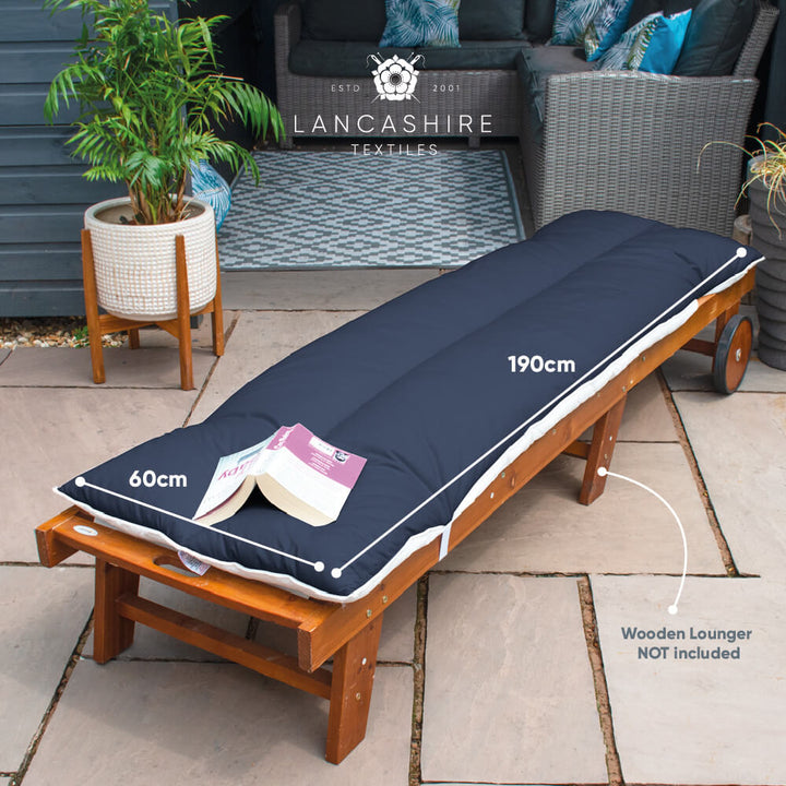 Lancashire Textiles Navy Blue Sun Lounger Topper on a wooden sun lounger in a garden. Product Dimensions 190cm long x 60cm wide.