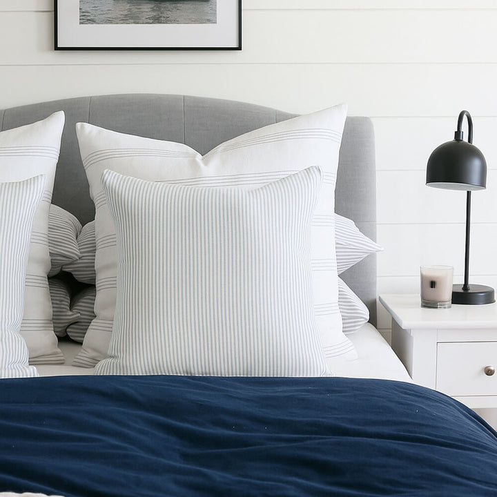 45cm x 45cm light blue and white striped scatter cushion on a bed