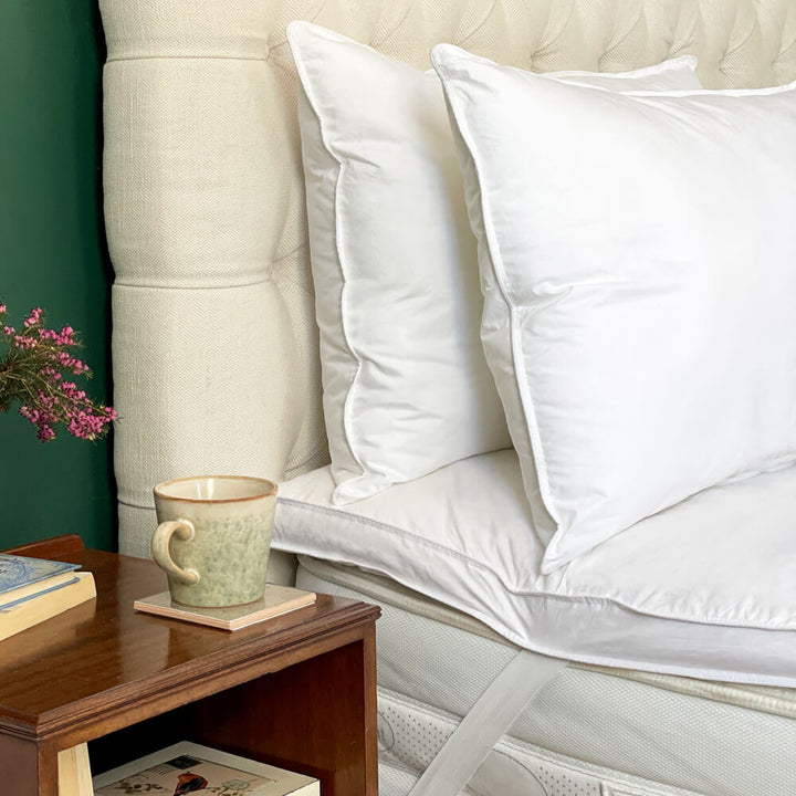 Duck feather mattress topper on a bed with cotton pillows