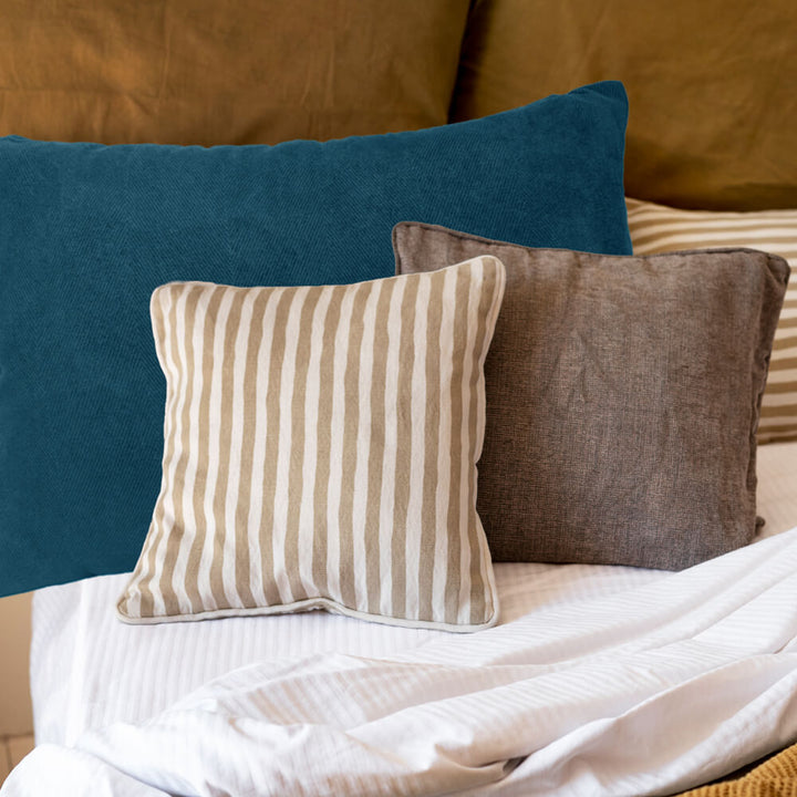 60cm x 40cm Blue herringbone fabric cushion cover shown on a bed with other scatter cushions 
