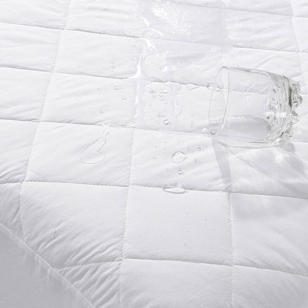 Quilted Waterproof Microfibre Mattress Protector with glass of water spilling onto it to depict the water resistance