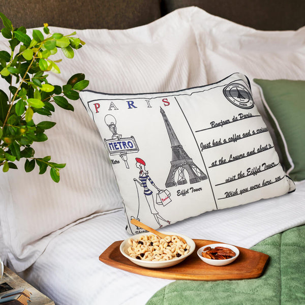Paris Postcard themed cushion on a bed