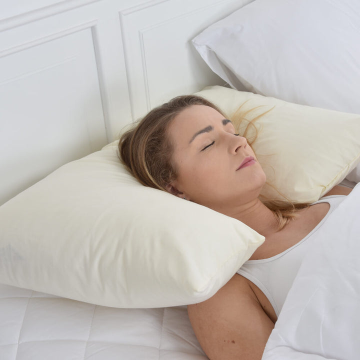 Cream polycotton spine align pillowcase on spine align support pillow with a woman sleeping on the pillow on her back in bed