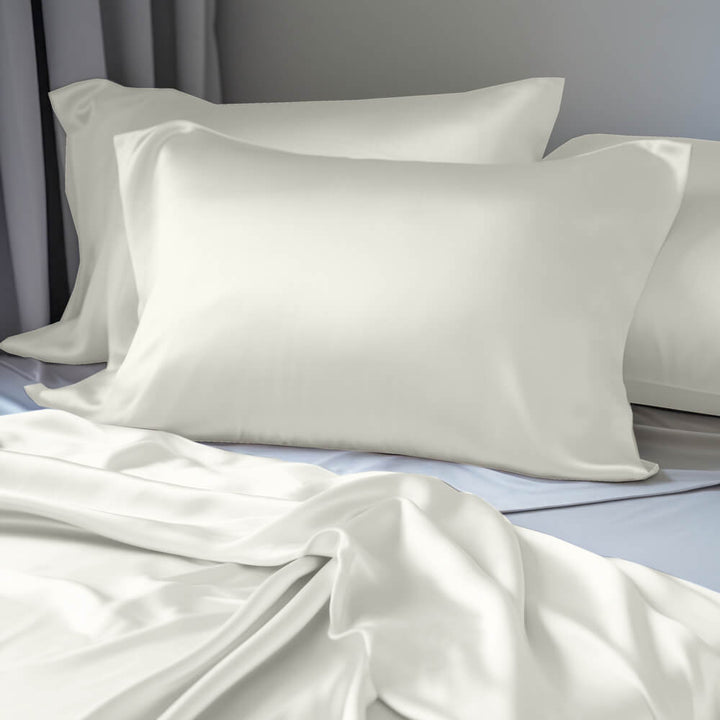 Cream mulberry silk pillowcases on pillows on a bed