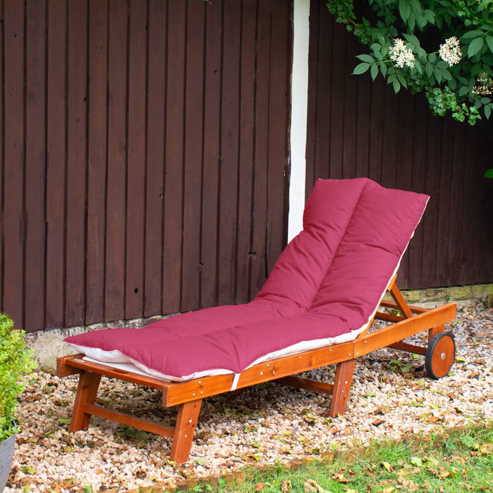Lancashire Textiles Wine coloured Sun Lounger Topper on a wooden sun lounger in a garden. 