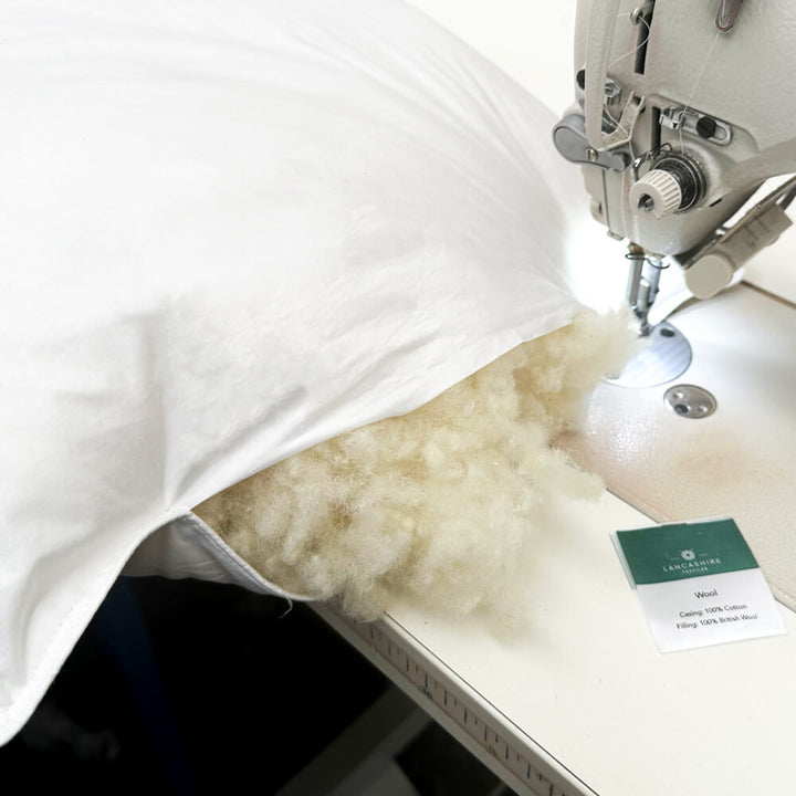 A British Wool Pillow being sewn, showing the filling inside